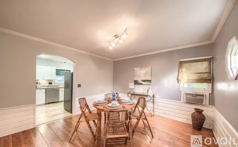 A dining room with a wooden table and chairs.