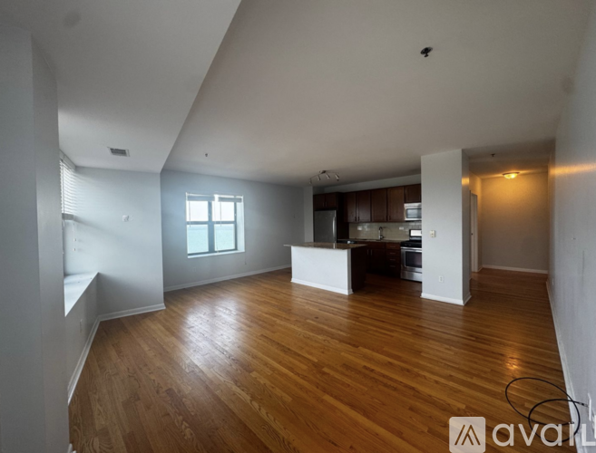A large empty room with wooden floors and white walls.