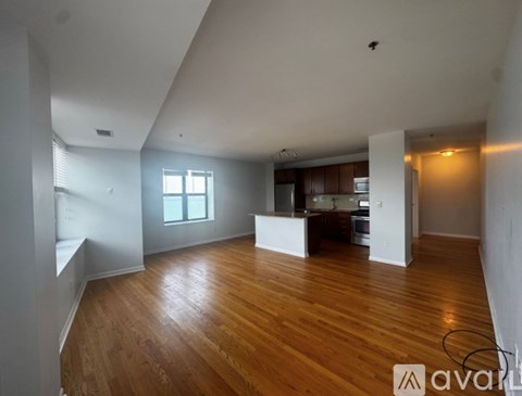 A large empty room with wooden floors and white walls.