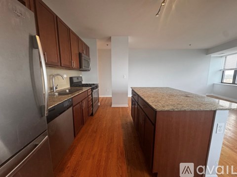 A kitchen with wooden cabinets and stainless steel appliances is available for rent.