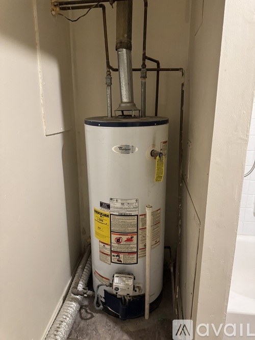 A water heater is installed in a narrow space.