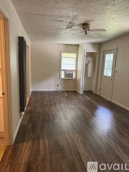 A room with wooden floors and a ceiling fan.