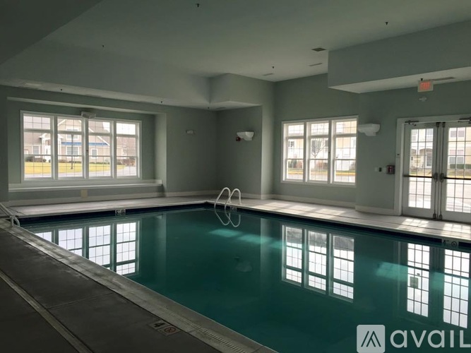 A large indoor swimming pool with a diving board.