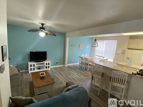 A living room with a television and a blue wall.