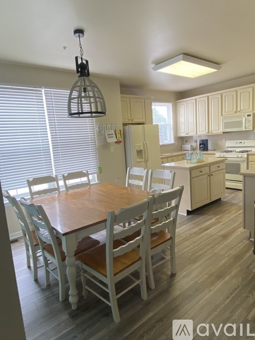 A kitchen with a table and chairs.
