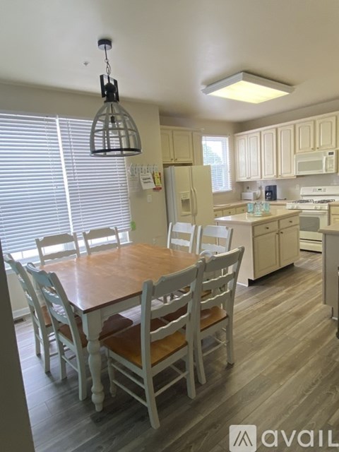 A kitchen with a table and chairs.