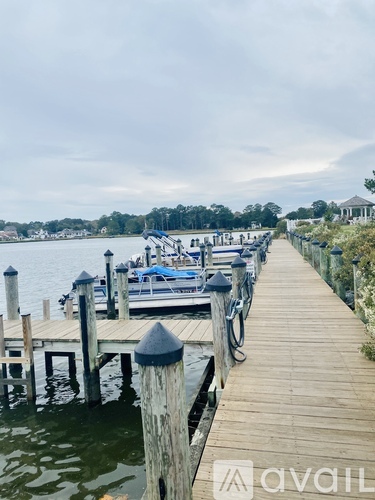 A dock with boats and a gazebo in the distance.