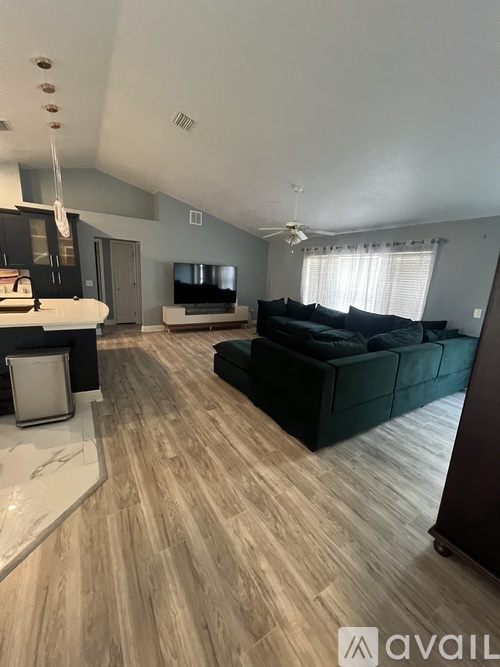 A living room with a black couch and a television.