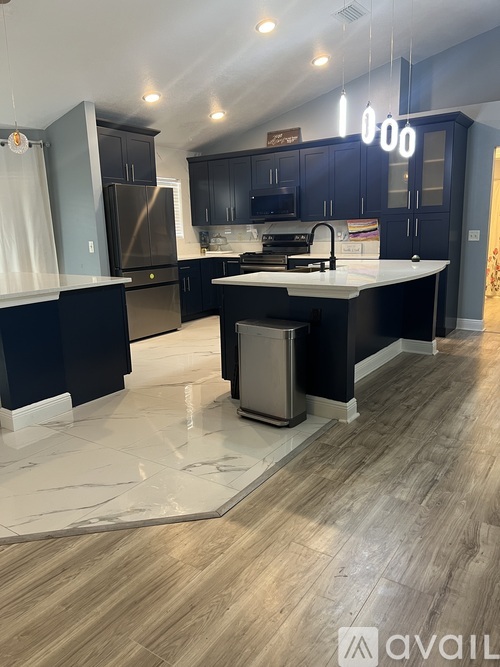 A kitchen with dark blue cabinets and a white countertop.