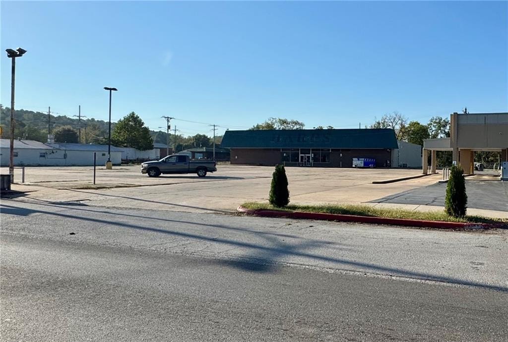 A parking lot with a building and a truck in the background.
