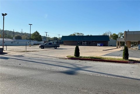 A parking lot with a building and a truck in the background.
