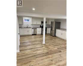 A kitchen with wooden floors and white cabinets.
