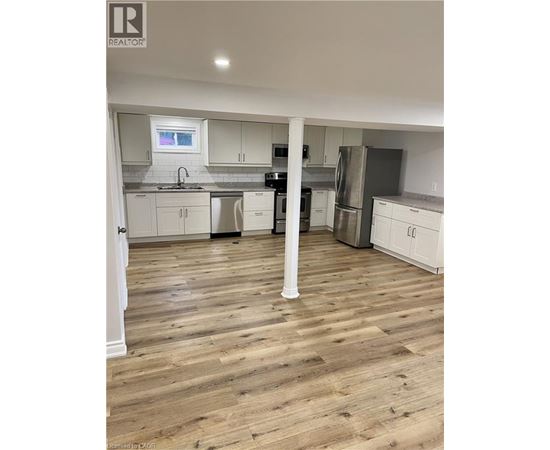 A kitchen with wooden floors and white cabinets.