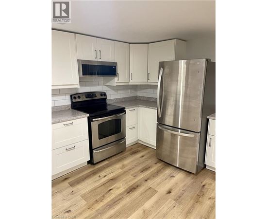 A kitchen with a stainless steel refrigerator and oven.