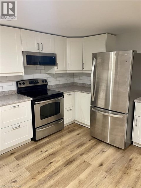 A kitchen with a stainless steel refrigerator and oven.