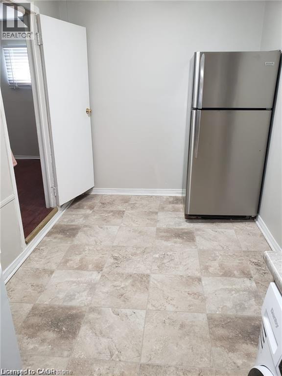 A kitchen with a fridge and a washing machine.