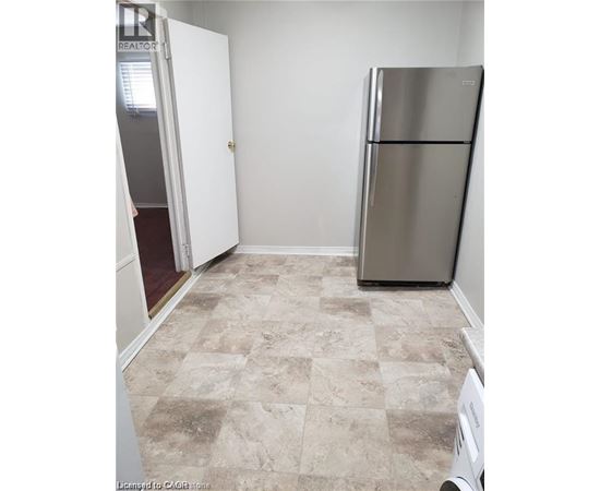 A kitchen with a fridge and a washing machine.