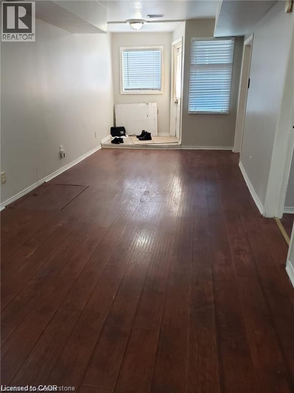 A room with wooden flooring and white walls.