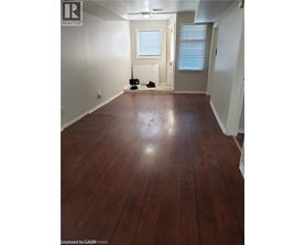 A room with wooden flooring and white walls.