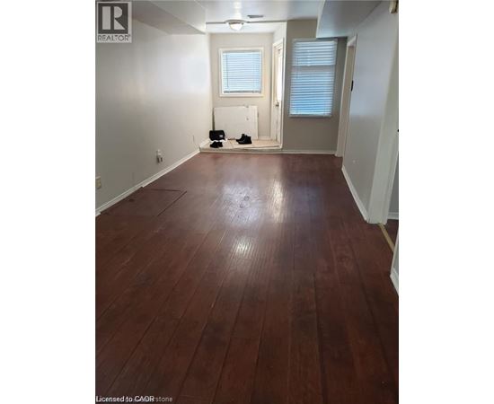 A room with wooden flooring and white walls.