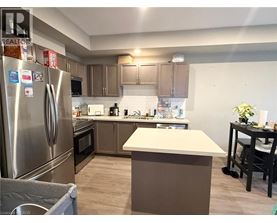 A kitchen with a refrigerator, oven, and countertop.