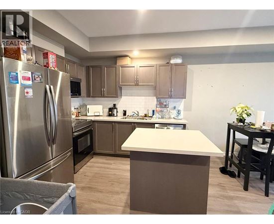 A kitchen with a refrigerator, oven, and countertop.