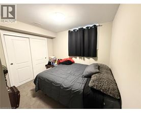 A bedroom with a bed, pillow, and a suitcase.
