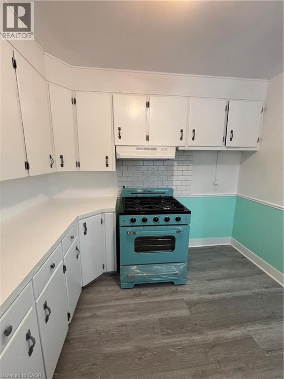 A kitchen with a blue stove and white cabinets.