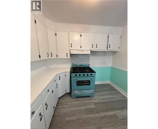 A kitchen with a blue stove and white cabinets.