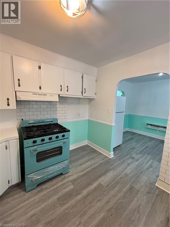 A kitchen with a blue stove and white cabinets.