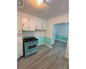 A kitchen with a blue stove and white cabinets.
