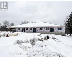 A house with a white roof and red trim is surrounded by snow.