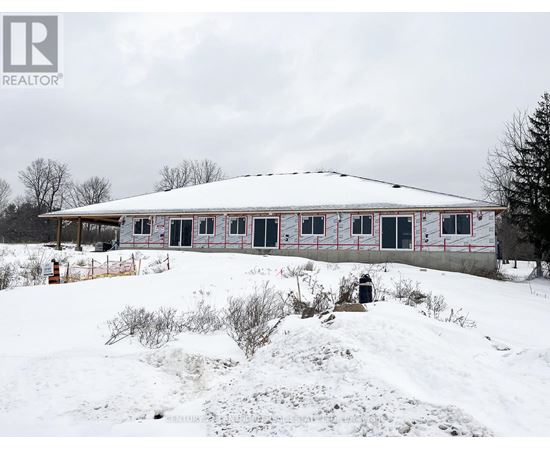 A house with a white roof and red trim is surrounded by snow.