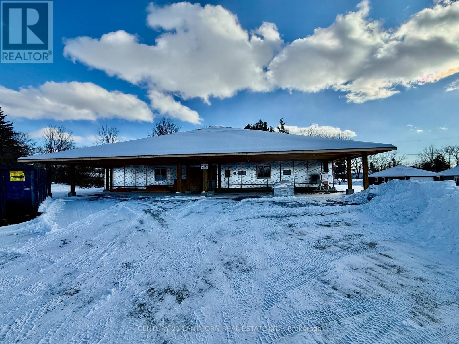A snow-covered building with a blue sky and clouds in the background.