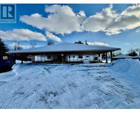 A snow-covered building with a blue sky and clouds in the background.