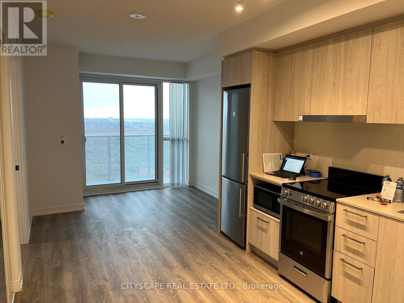 A kitchen with wooden cabinets and a stainless steel refrigerator.