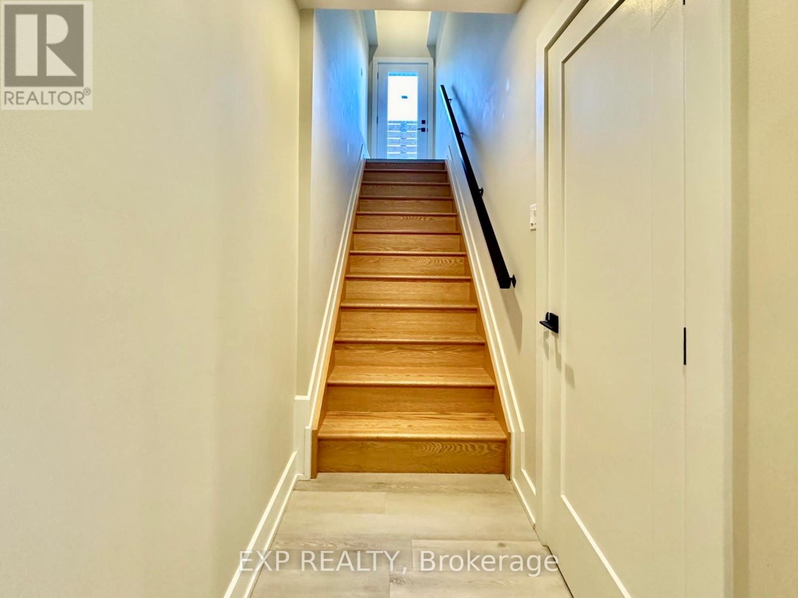 A long flight of wooden stairs leads to a door.