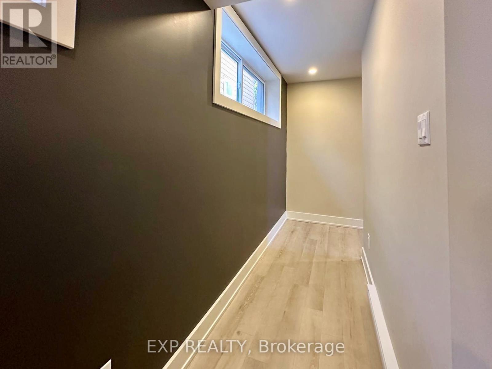 A room with a window and wooden flooring.