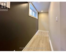 A room with a window and wooden flooring.