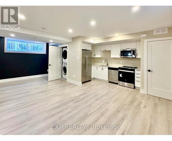 A spacious kitchen with white cabinets and a black countertop.
