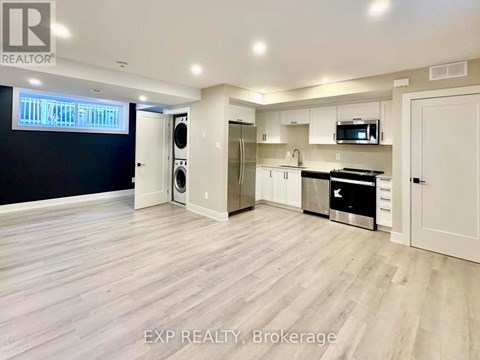 A spacious kitchen with white cabinets and a black countertop.