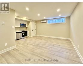 A spacious room with wood flooring and a window.