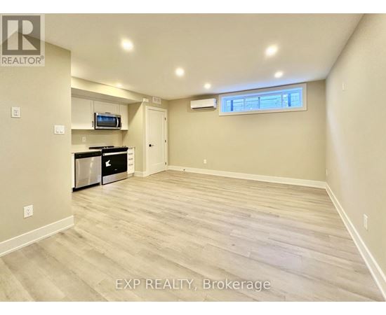 A spacious room with wood flooring and a window.