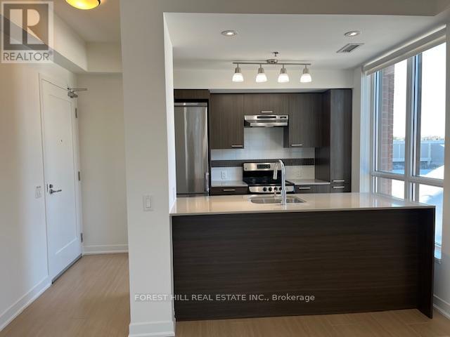 A kitchen with a counter top and a stainless steel refrigerator.