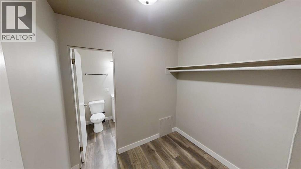 A white bathroom with a toilet and a shelf.