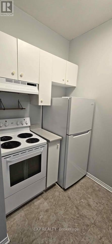 A kitchen with white appliances and cabinets.