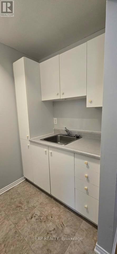 A kitchen with white cabinets and a sink.