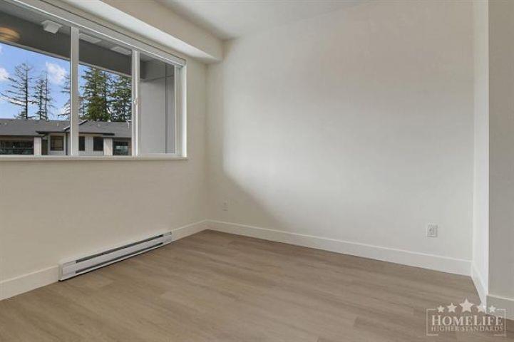 A room with a window overlooking a house and trees.