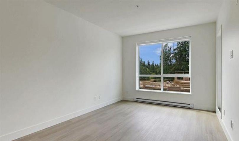 A spacious room with a large window overlooking a construction site.