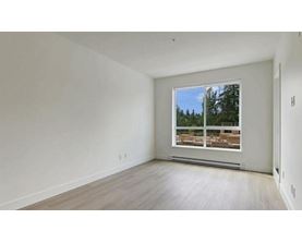 A spacious room with a large window overlooking a construction site.